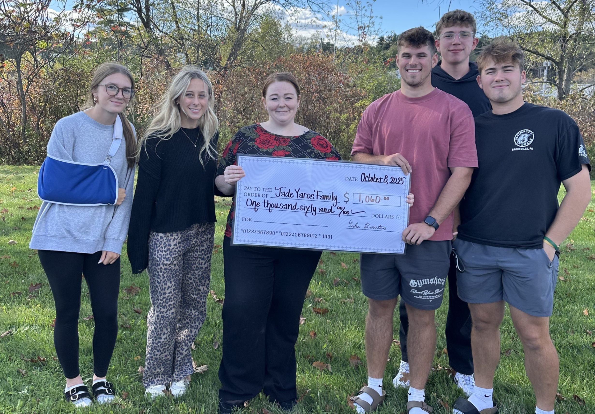 Luke Burton and other students present a check to Christin Ferringer.